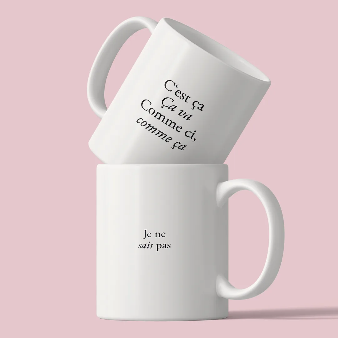 Two stacked C’est ça mugs against a pink background, the back reading Je ne sais pas below