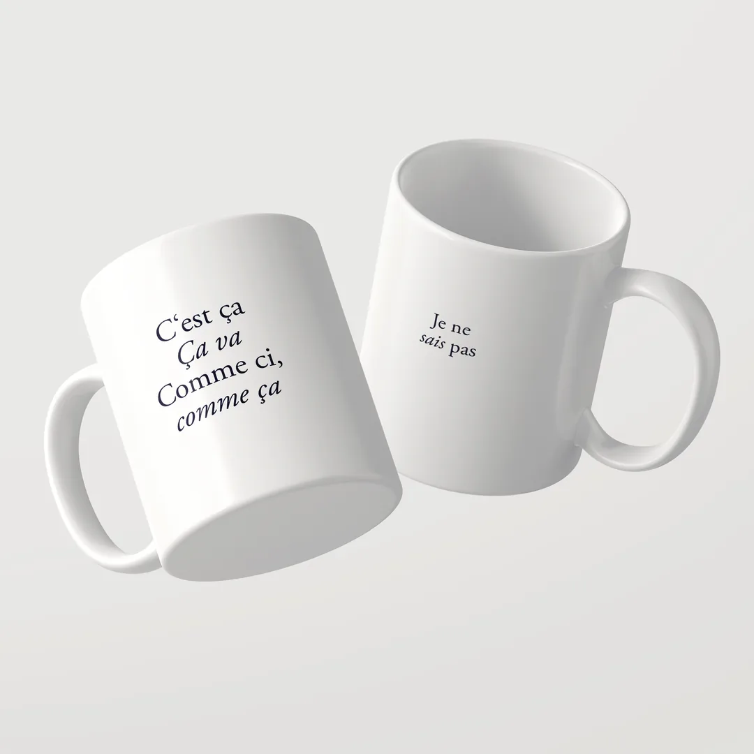 Two white C’est ça mugs by Studio SaySay, French on the front, Je ne sais pas on the back