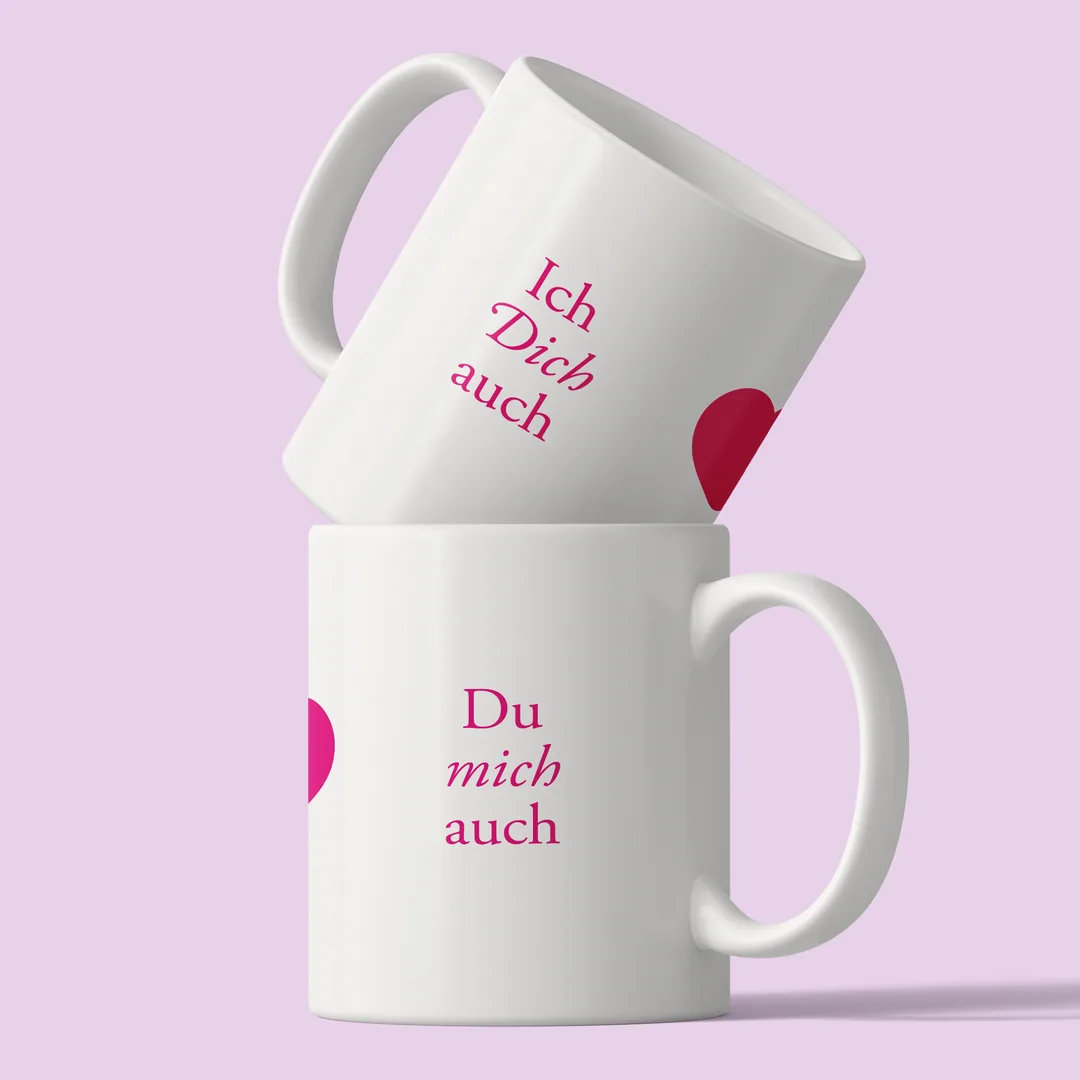 Zwei gestapelte Ich dich auch Tassen vor fliederfarbenem Hintergrund, oben Ich Dich auch, unten Du mich auch