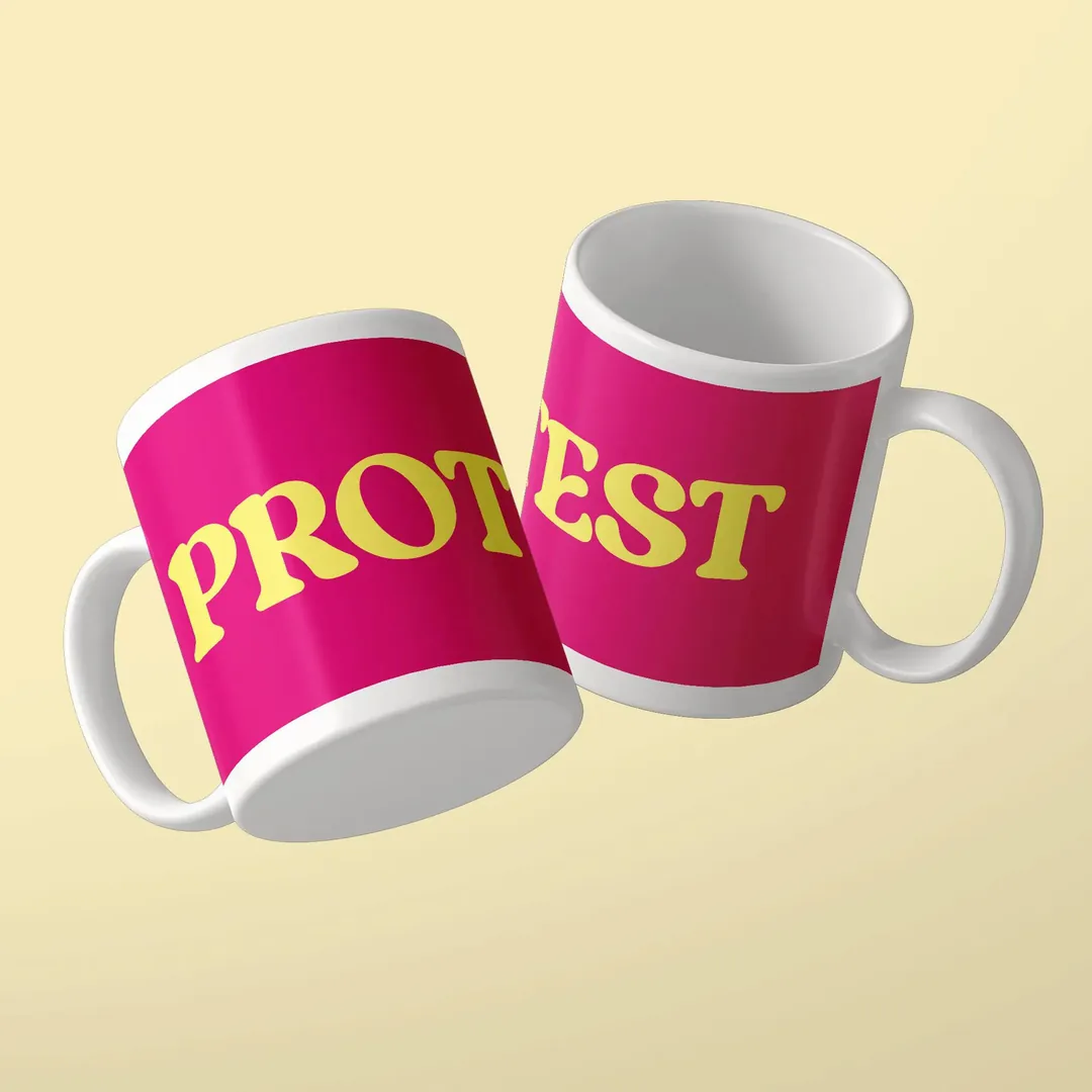 Two pink mugs with the yellow lettering PROTEST, mug by Studio SaySay