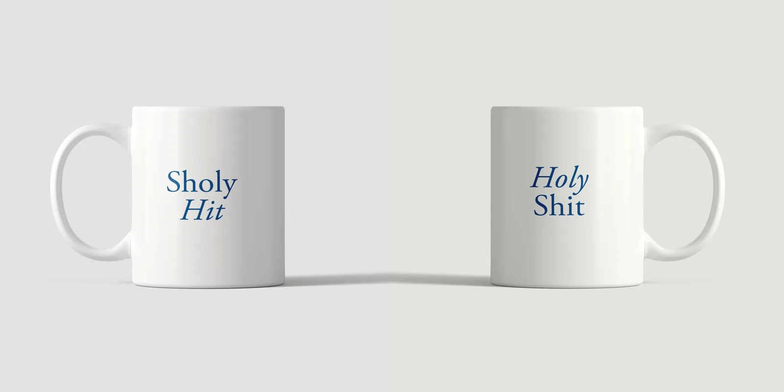 Front of the Sholy Hit mug and the back reading Holy Shit, side by side, in blue serif type